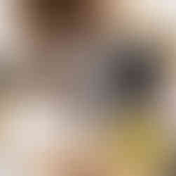 Flat lay view of woman's hands writing on a pad of paper next to her laptop