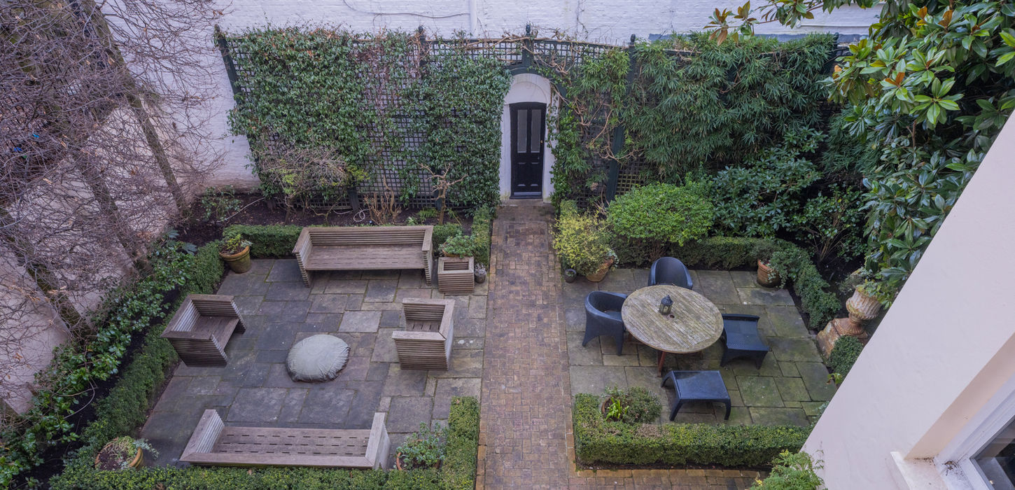 Overhead view of private paved courtyard garden with outdoor seating and brick pathway at Gloucester Lodge