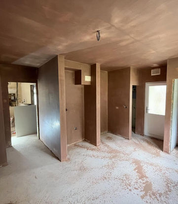Interior renovation of a room with several doorways and unfinished walls.