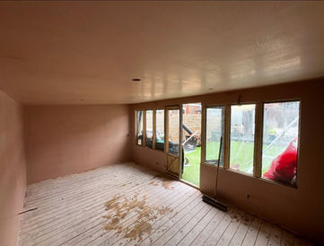 Interior room with exposed beams and glass doors, outside view. HOME
