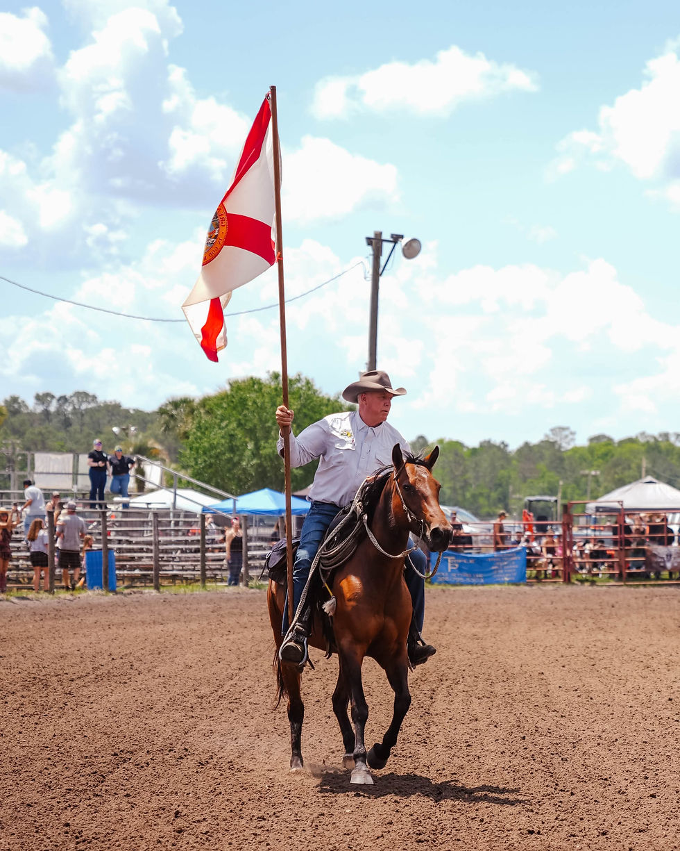 Man riding a horse holding a Florida flag.