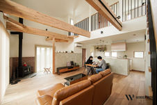 2人掛けソファのある開放的なリビング、木製の梁と高い天井