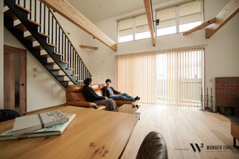 開放的なリビングでくつろぐ男女。
