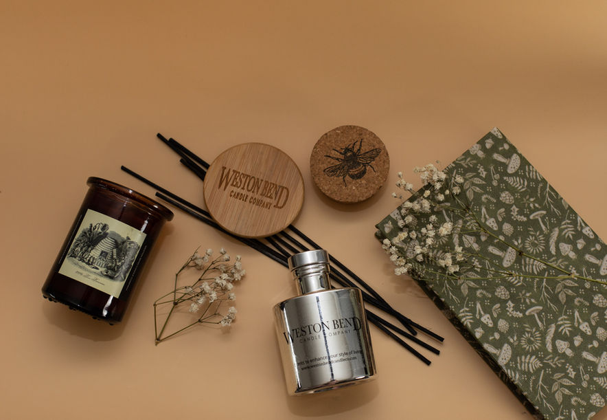 A scented, all-natural beeswax candle made with essential oils, and a bamboo reed diffuser.