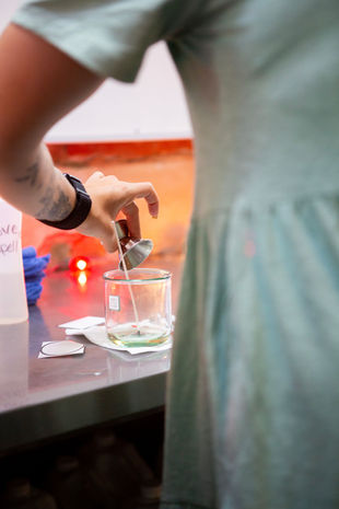 Woman pouring scented oils into a candle.