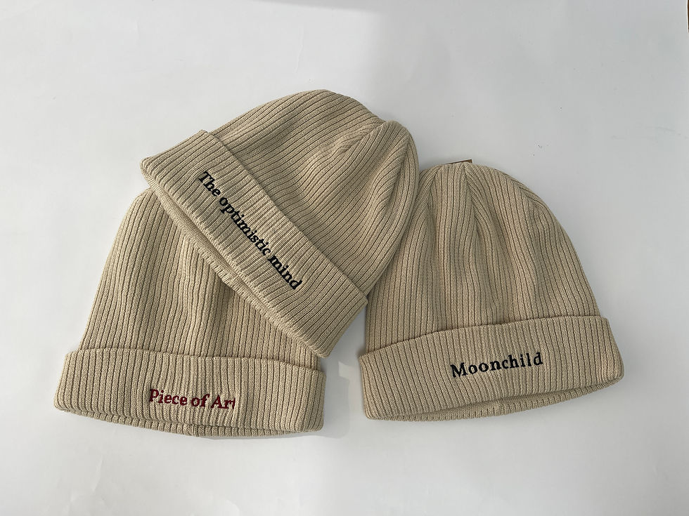 beige beanie with embroidery of a the optimistic mind