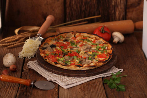 Delicious veggie pizza topped with fresh tomatoes, bell peppers, olives, mushrooms, and mozzarella cheese at Palatium Cafe & Restaurant.