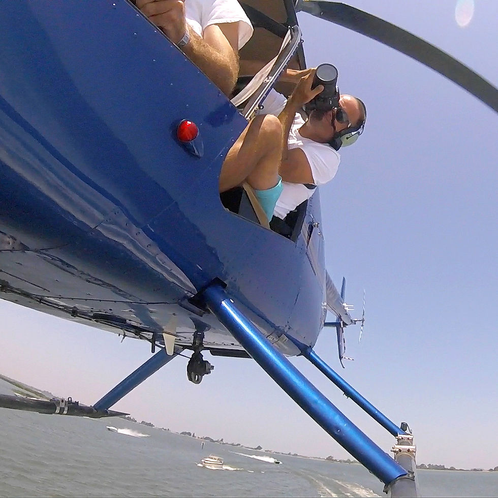 Photographer hanging out of helicopter