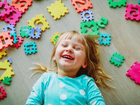children lying on the floor with letter mats