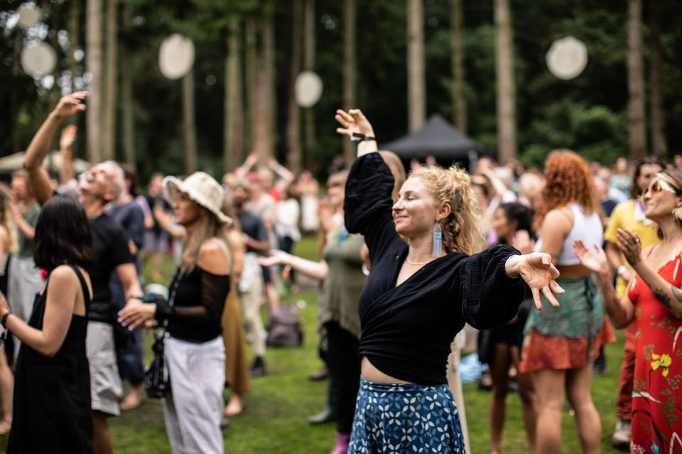Candid photo of a woman dancing joyfully at an outdoor festival in London