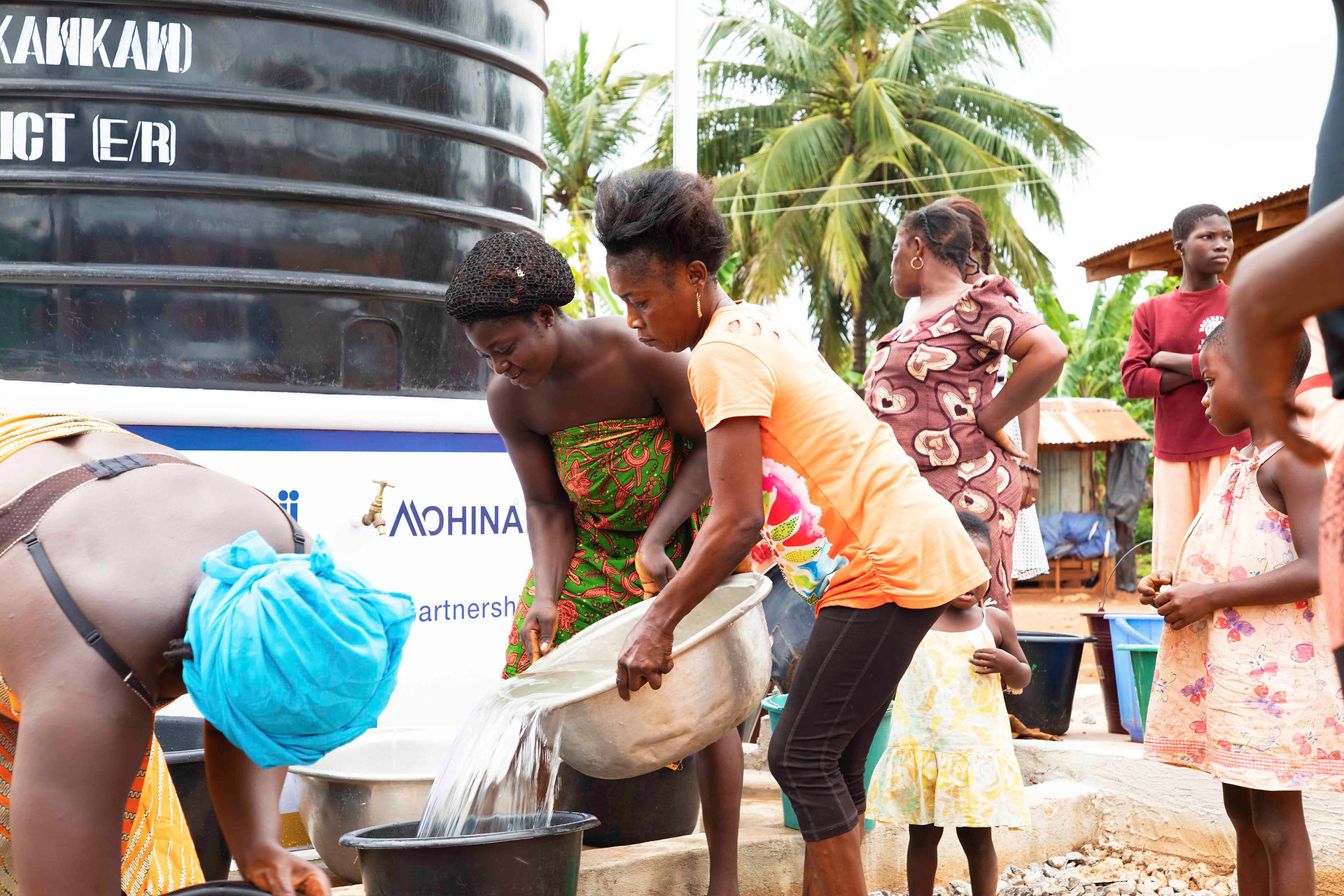 Women filling buckets with clean water at Maji water tank