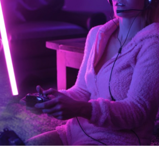 girls playing playstation gaming, purple light in comfy clothes at home, headset and pink LED tube light