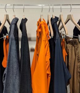 bright orange and denim rails on wooden hangers