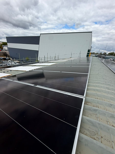 Rows of black solar panels installed on a commercial building rooftop