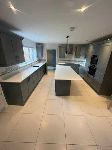 Modern kitchen refurbishment with dark cabinets and white island