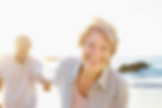 Smiling older woman with white teeth on a beach