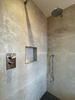 Modern wet room shower with rainfall showerhead and built in wall niche