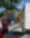Removals men carrying a large, ornate mirror into a van