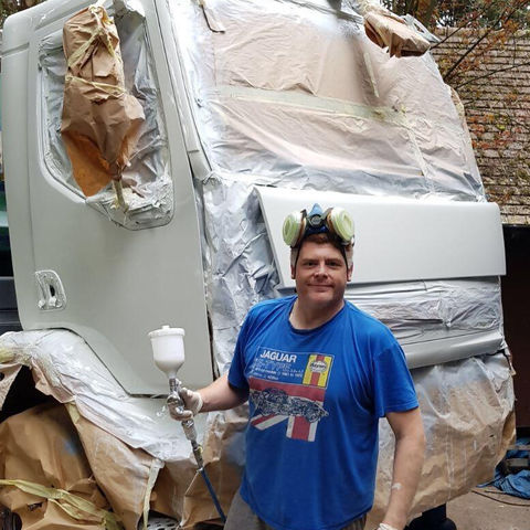 Spraying a skip lorry cab with paint