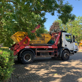 Skip lorry parked trees under 