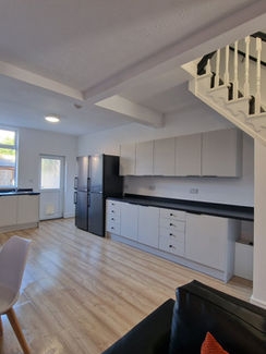 Modern open-plan kitchen and living space with staircase