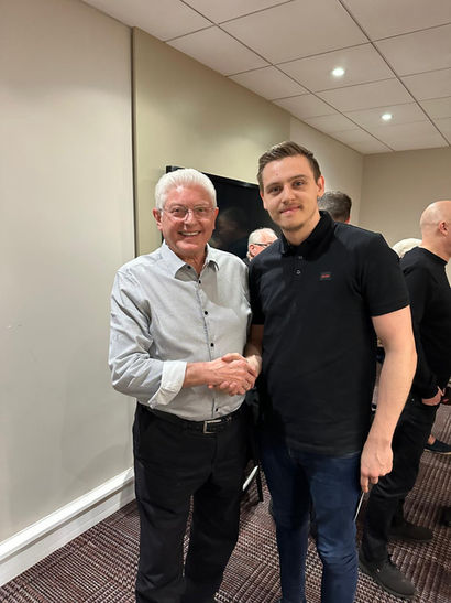 A snooker coach shaking hands with a snooker player.