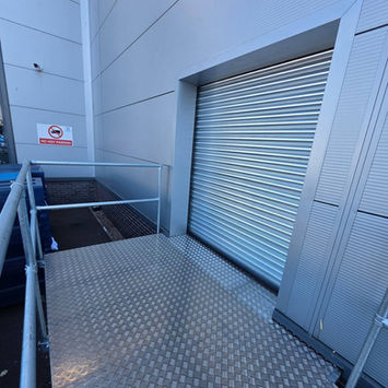 Industrial roller shutter door with metal loading ramp