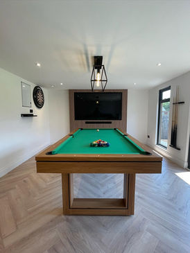Modern garden room interior with a pool table and TV.