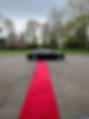 Red carpet rolled out to black luxury car
