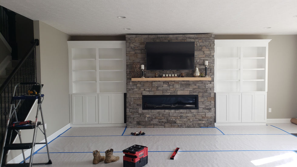 TV and fireplace centered between tall white built-in cabinets.