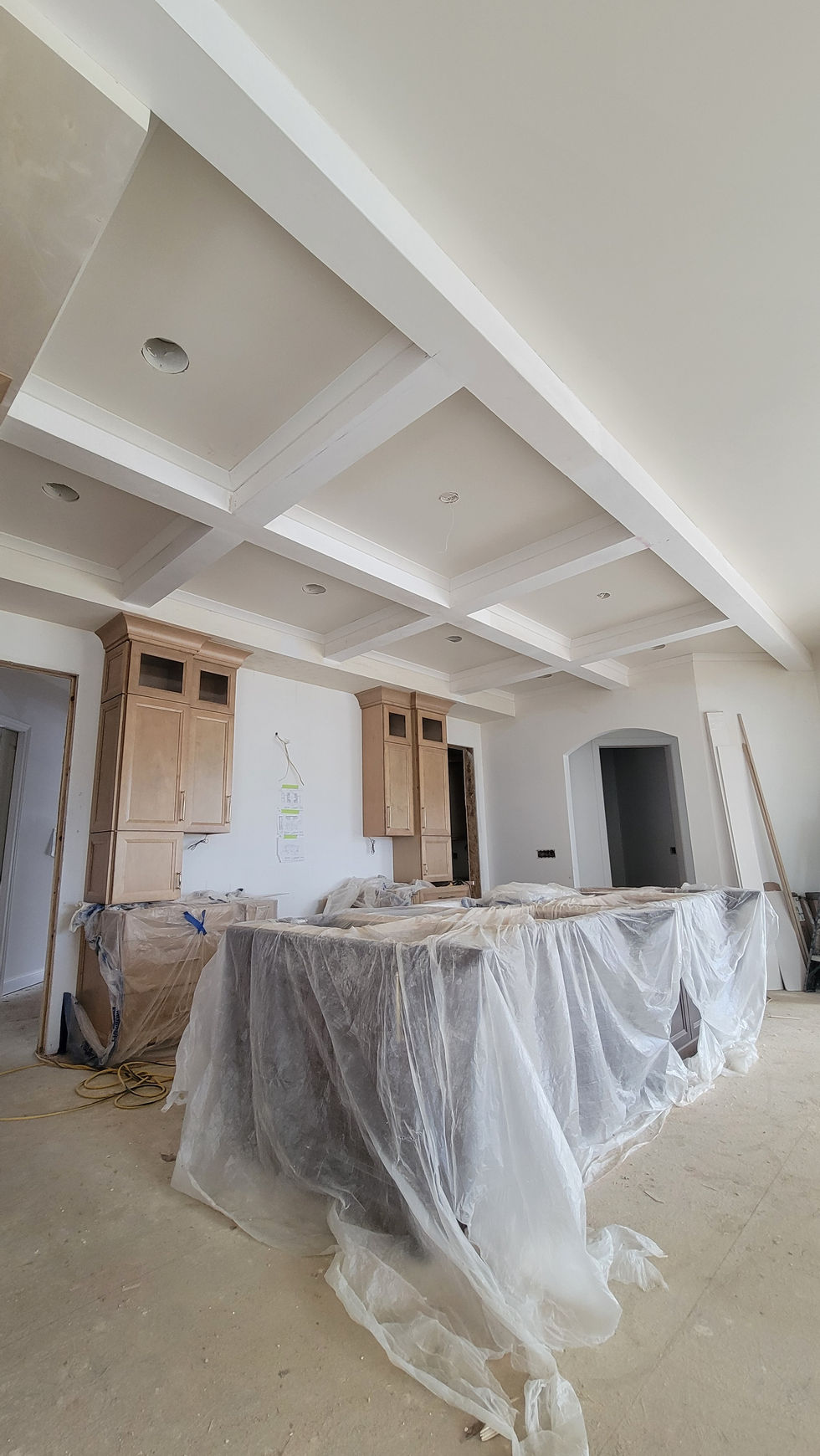 White coffered ceiling above a kitchen area with covered counters.