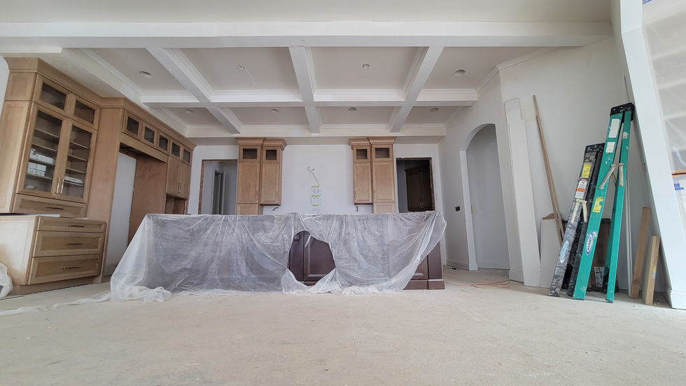 White coffered ceiling installed above a large open interior room.