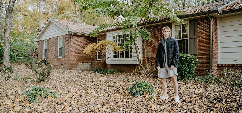 Corey Lavinder Standing in front of house in the fall