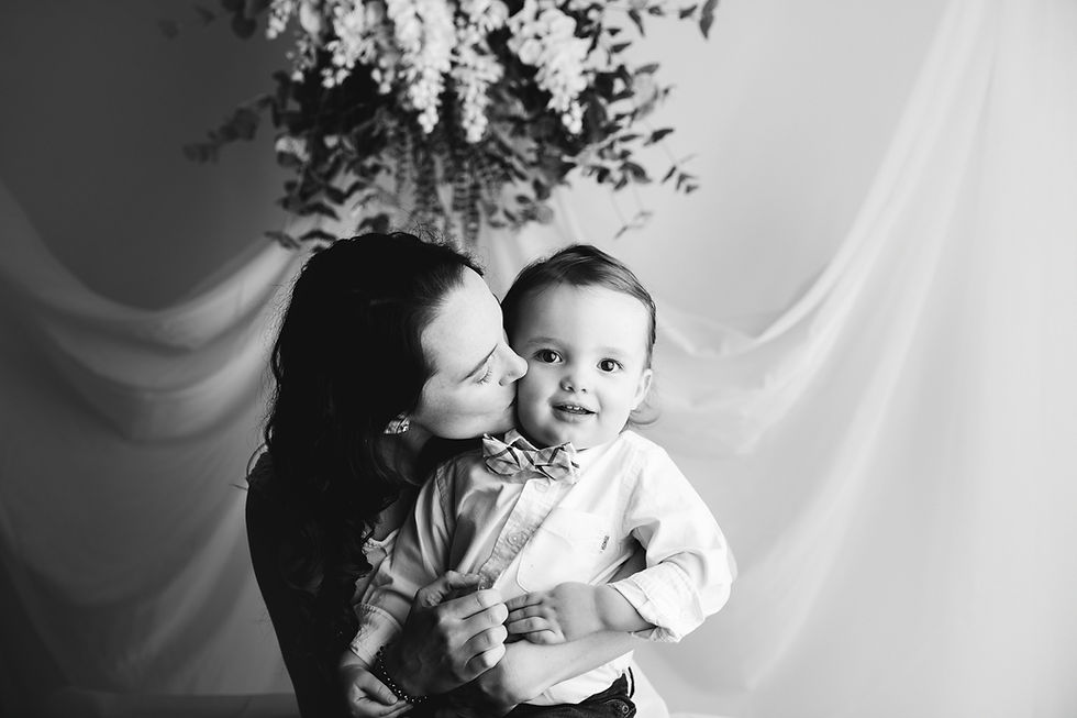 black and white mom kissing her toddler boy