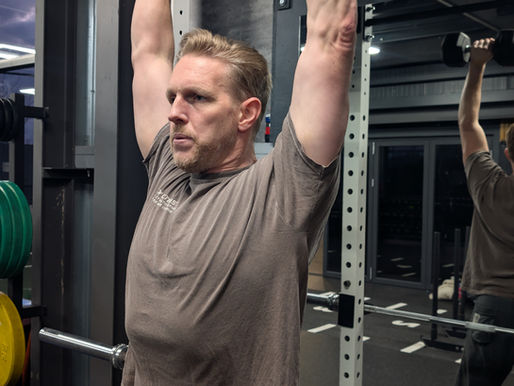 A man performing a dumbbell overhead press
