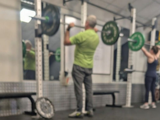 Two lifter at a rack doing an overhead press