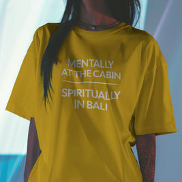 Minimalist travel graphic tee with the phrase "Mentally at the Cabin, Spiritually in Bali", blending cozy cabin vibes with tropical Bali energy for adventurous, nature-loving women.