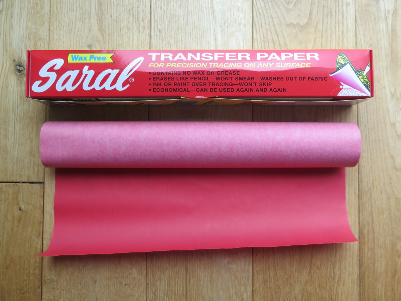 Saral transfer paper box and a roll of red paper