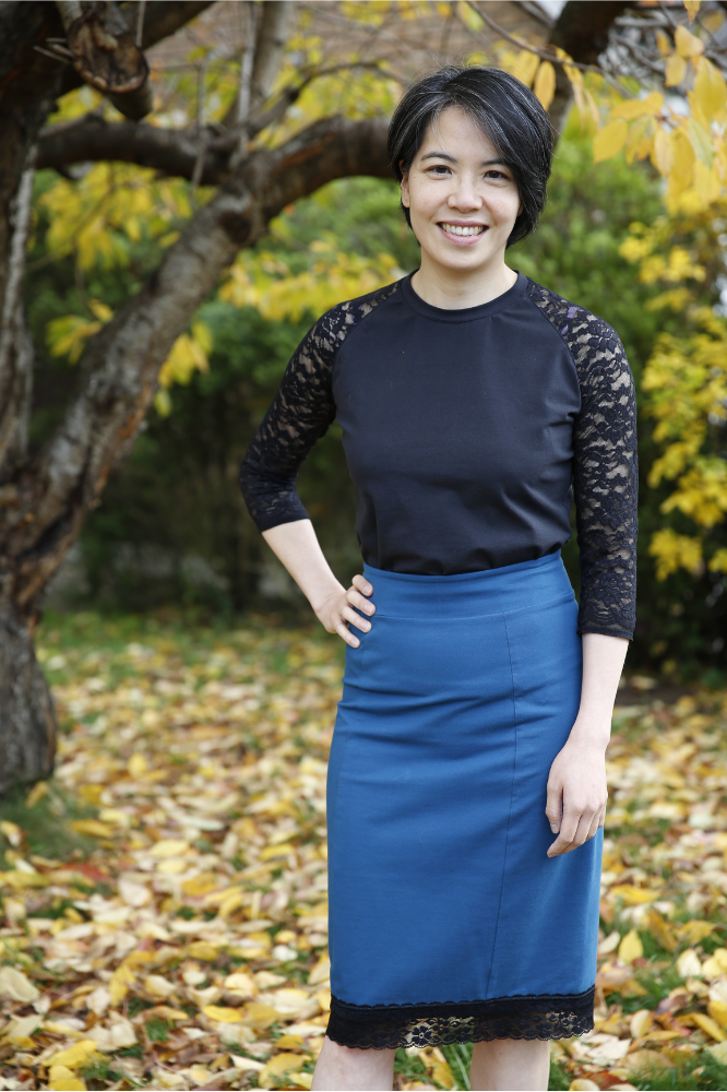 Front view of Tilly and the Buttons Frankie T-Shirt in black jersey with black lace sleeves, tucked into petrol Bibi Skirt with black lace trim