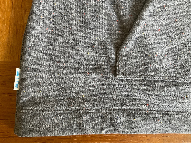 Kylie & The Machine side seam label saying CAN'T STOP on the Tilly and the Buttons Stella Hoodie on grey multi-fleck sweatshirt fabric, showing neat 2 needle coverstitching on the hem and kangaroo pocket