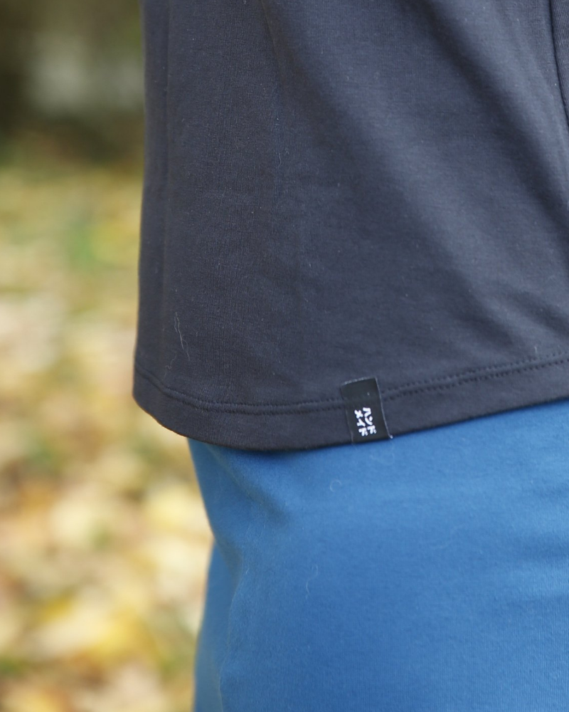 Close up view of the Tilly and the Buttons Frankie T-Shirt curved hem showing neat 2 needle coverstitching with a hem label sewn in place which says handmade in Japanese