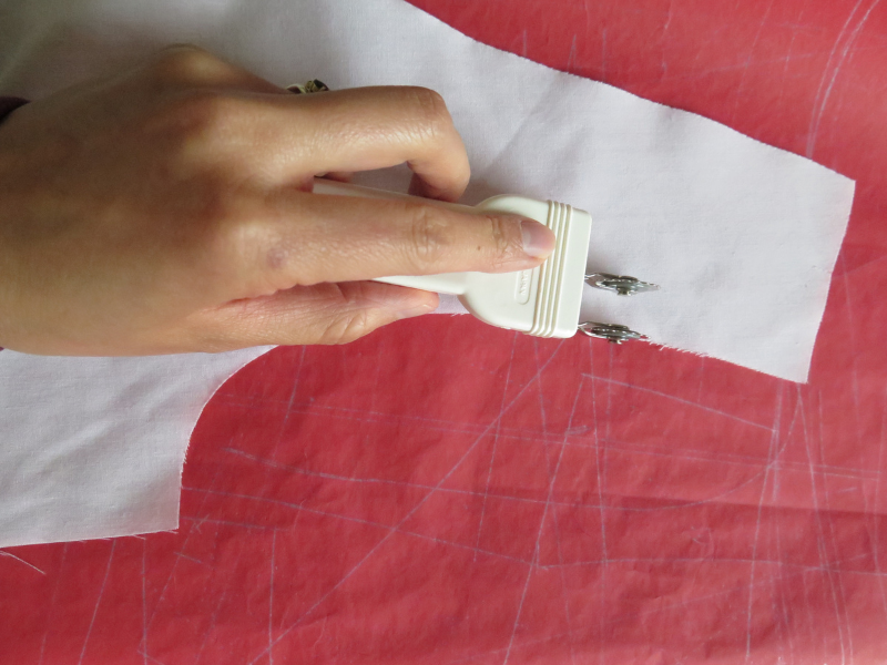 Using the Clover double tracing wheel on red Saral transfer paper to mark the seam allowance around the armhole