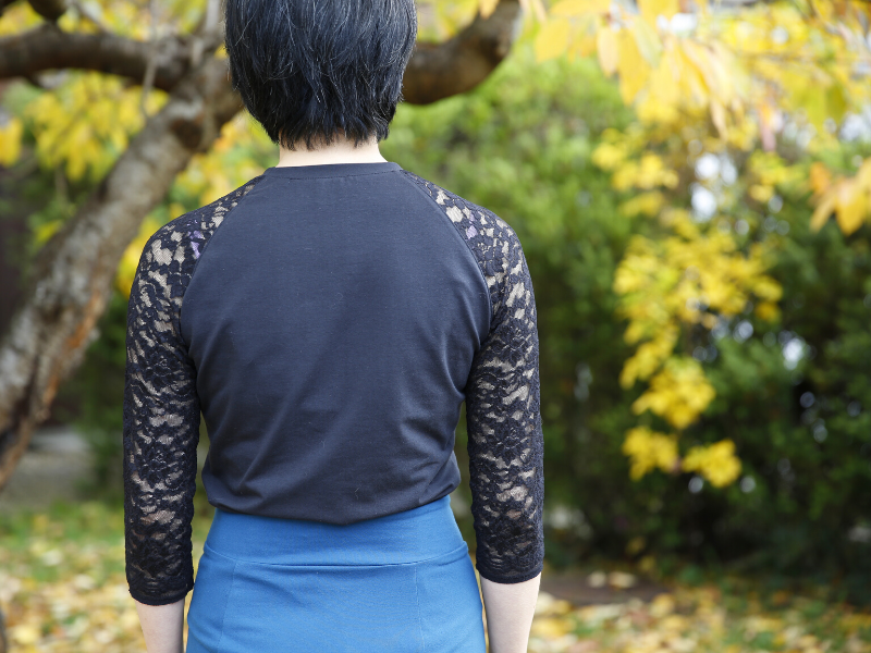 Full back view of Tilly and the Buttons Frankie T-Shirt in black jersey with black lace 3/4 sleeves and tucked into the Bibi Skirt