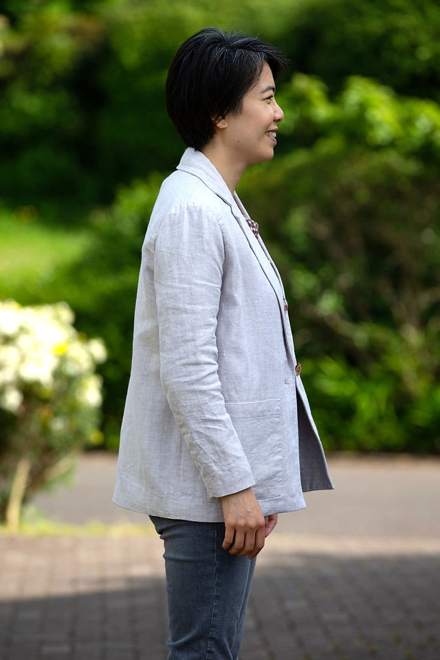 Right view of young Asian female in finished Heather Blazer in white linen