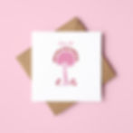 An illustrated greeting card to celebrate the birth of a baby girl. The card rests on a brown envelope and pink background.