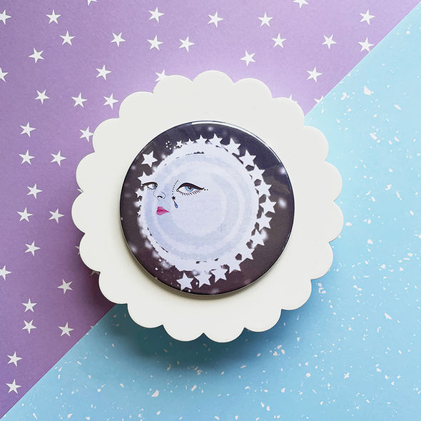 A hand-held Pocket Mirror showing a beautifully illustrated crying moon and stars.