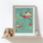 A colourful, illustrated, framed "Party Animals" print of hopping frogs. The artwork rests on a toy shelf in a nursery.