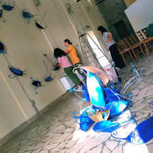 fotografia del montaggio di un'installazione artistica, formata da sculture che riproducono barche stilizzate in ferro e carta dipinta di blu e azzurro.
