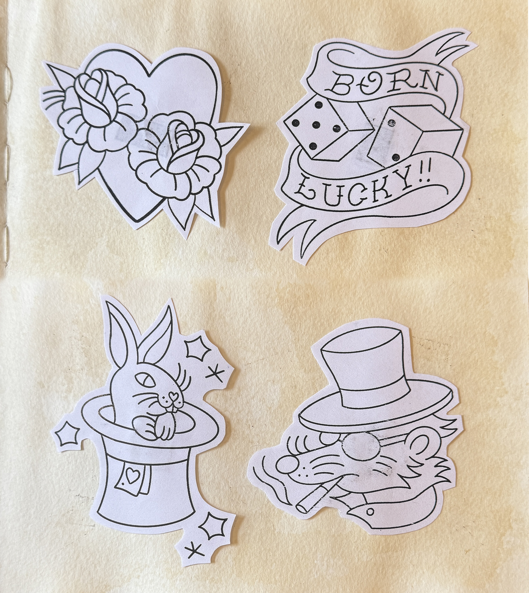 American traditional tattoo flash by Athena Jones at Capital Tattoo St Paul MN - heart with roses, Born Lucky dice, bunny in top hat, smoking rat with top hat