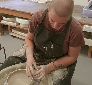Ellie throwing a white bowl on the pottery wheel